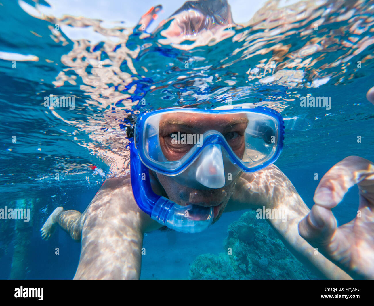 Snorkeling guy underwater doing scuba ok sign in the Red sea Stock Photo