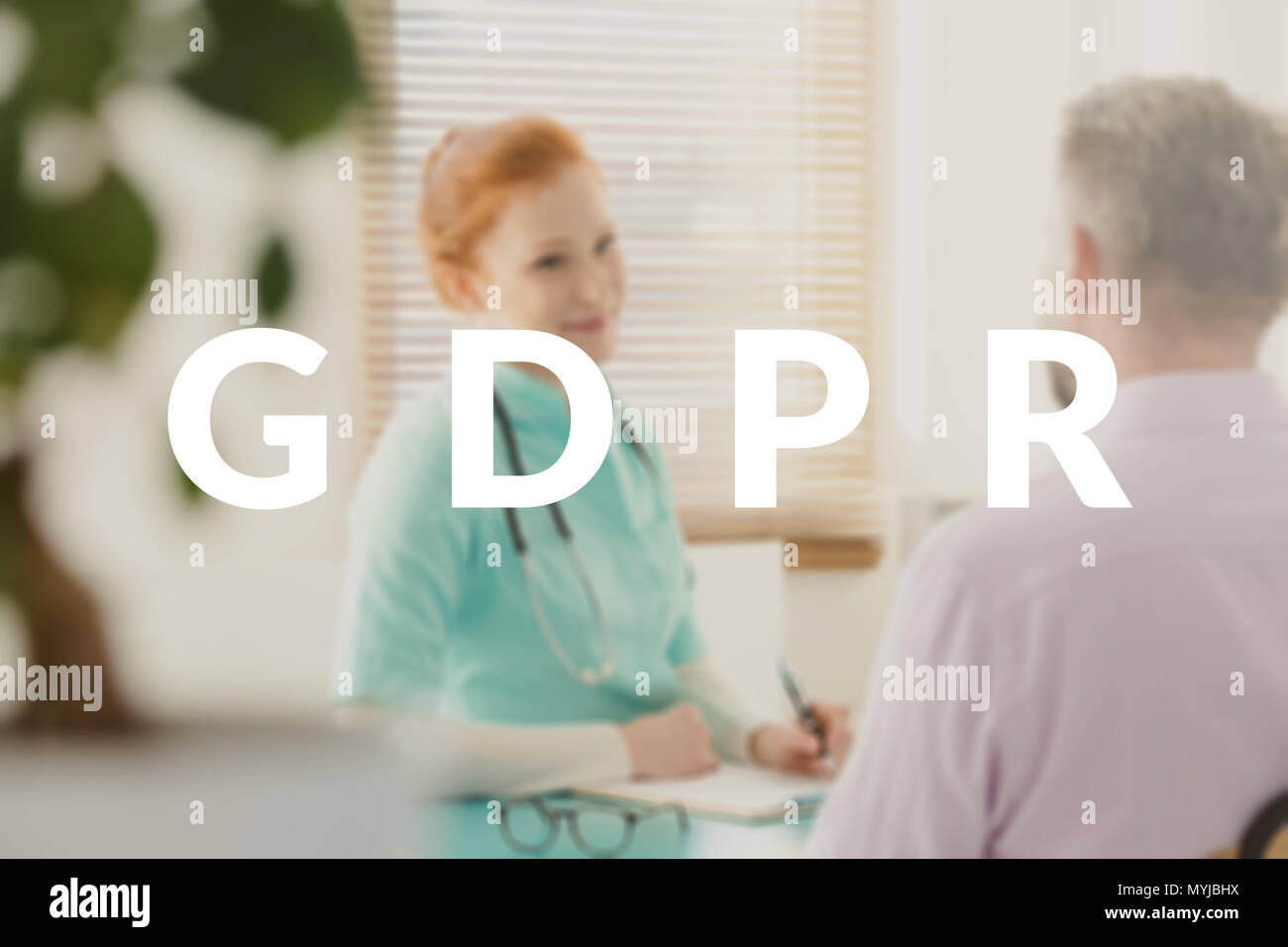 Young, female doctor explaining new GDPR related policy to her patient. White text on a blurred photo Stock Photo