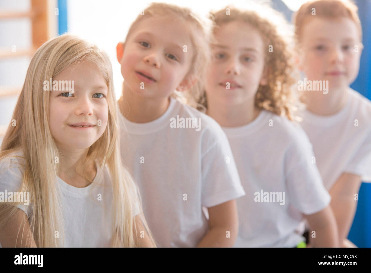 Close-up of smiling blonde girl with friends at the school gym Stock Photo