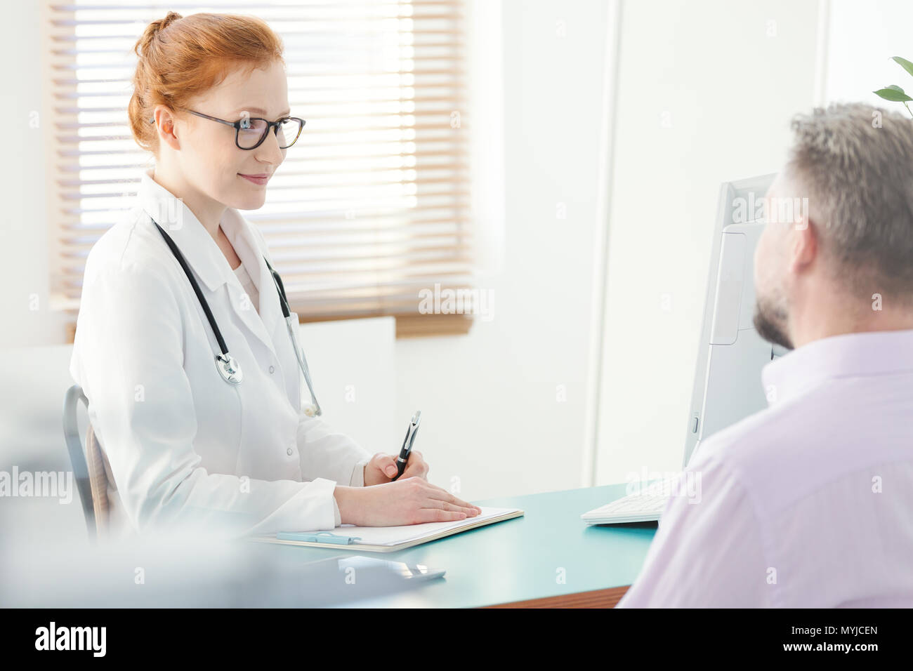 Smiling urologist explaining a problem to a patient in the clinic Stock Photo
