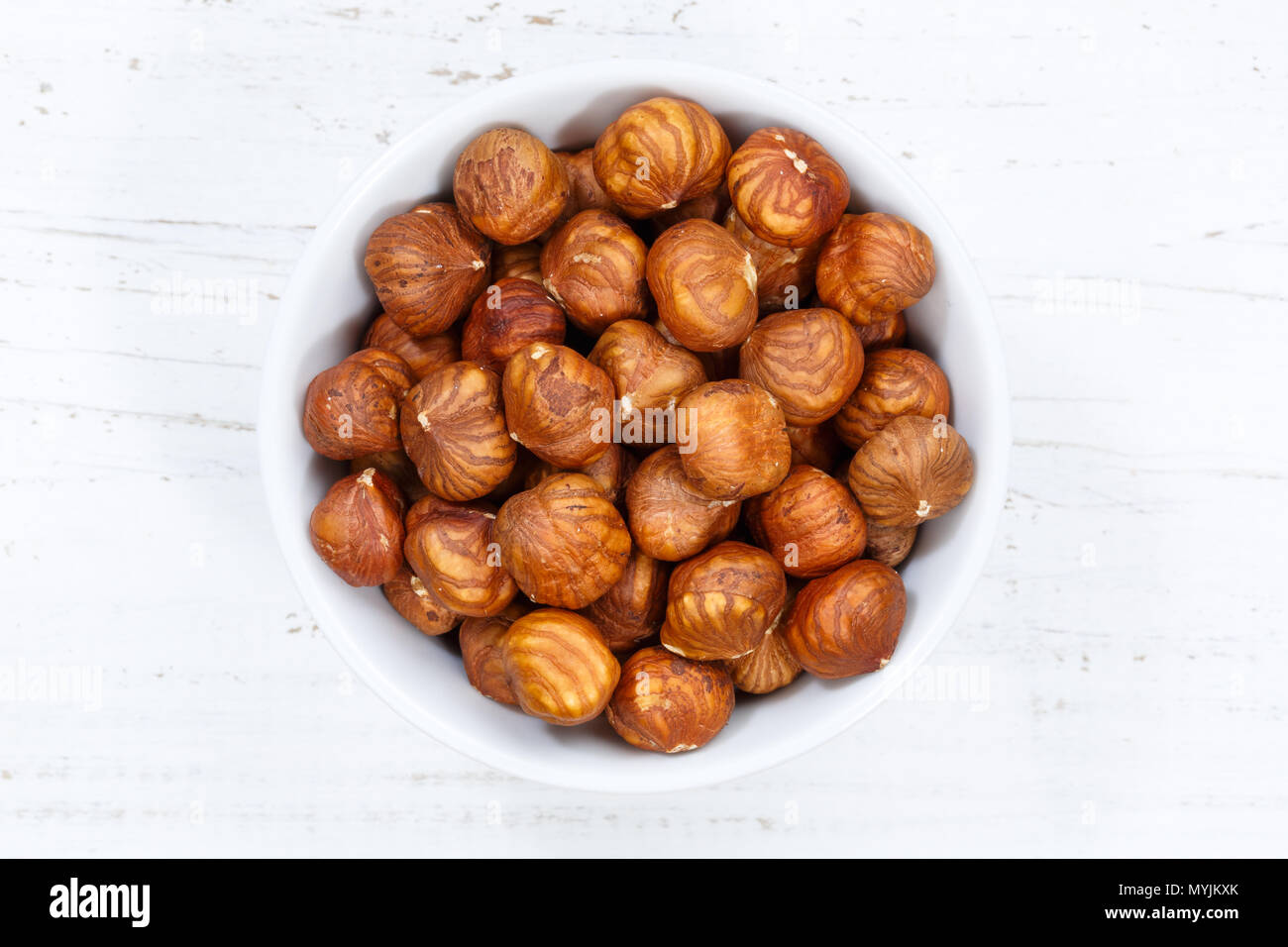 Hazelnuts nuts from above bowl wooden board wood Stock Photo