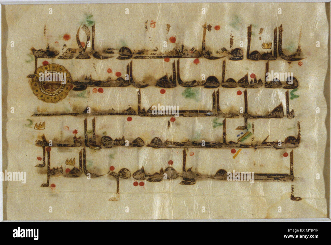 . English: The beginning of verse 19 from the 5th chapter of the Qur'an entitled al-Ma'idah (The Table). The text is exectued in a Kufi script similar to style D.Vb, at 5 lines per page in horizontal format. This particular script is differentiated by the upper stroke of the letter kaf (k) which slants to the right before turning to the left. The text is executed in black ink, while red dots indicating vocalization may have been added later. Diacritical marks also appear to have been added subsequently: for example, glottal stops (hamza) are marked in green ink, while duplications of consonant Stock Photo