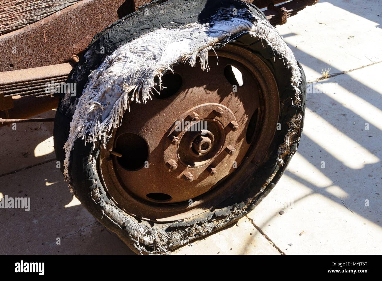 Old worn rag car (tyre) tire, on rusty wheel, Western Australia April