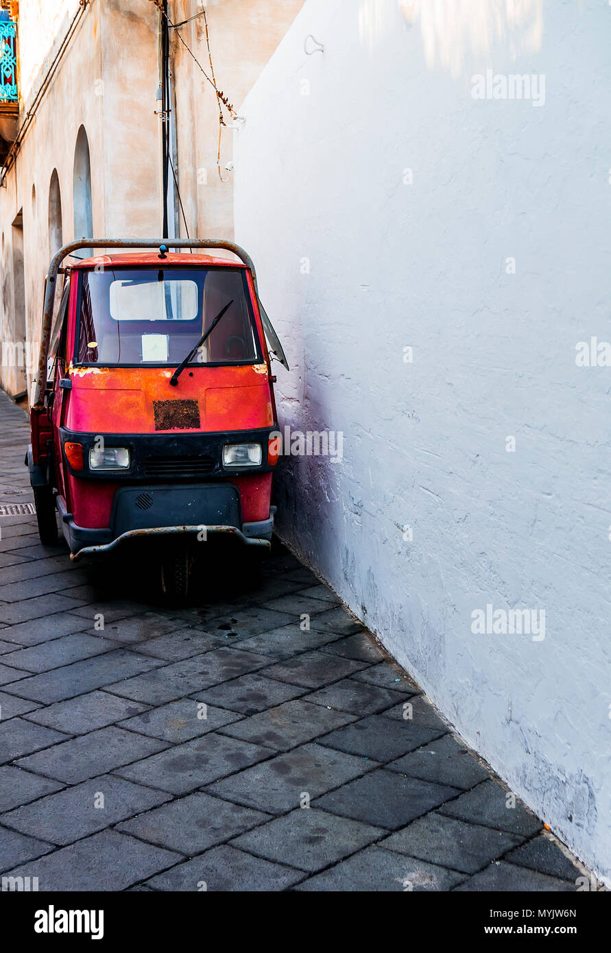 Tiny truck / car in Italy parked on the side of a road. Frontal view Stock Photo