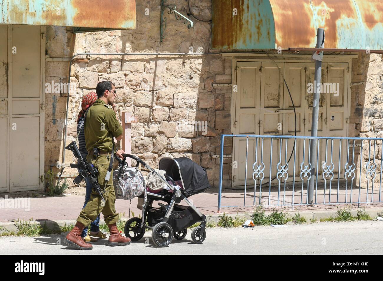 Israeli soldier with gun and buggy , Hebron, April 4, 2018 usage