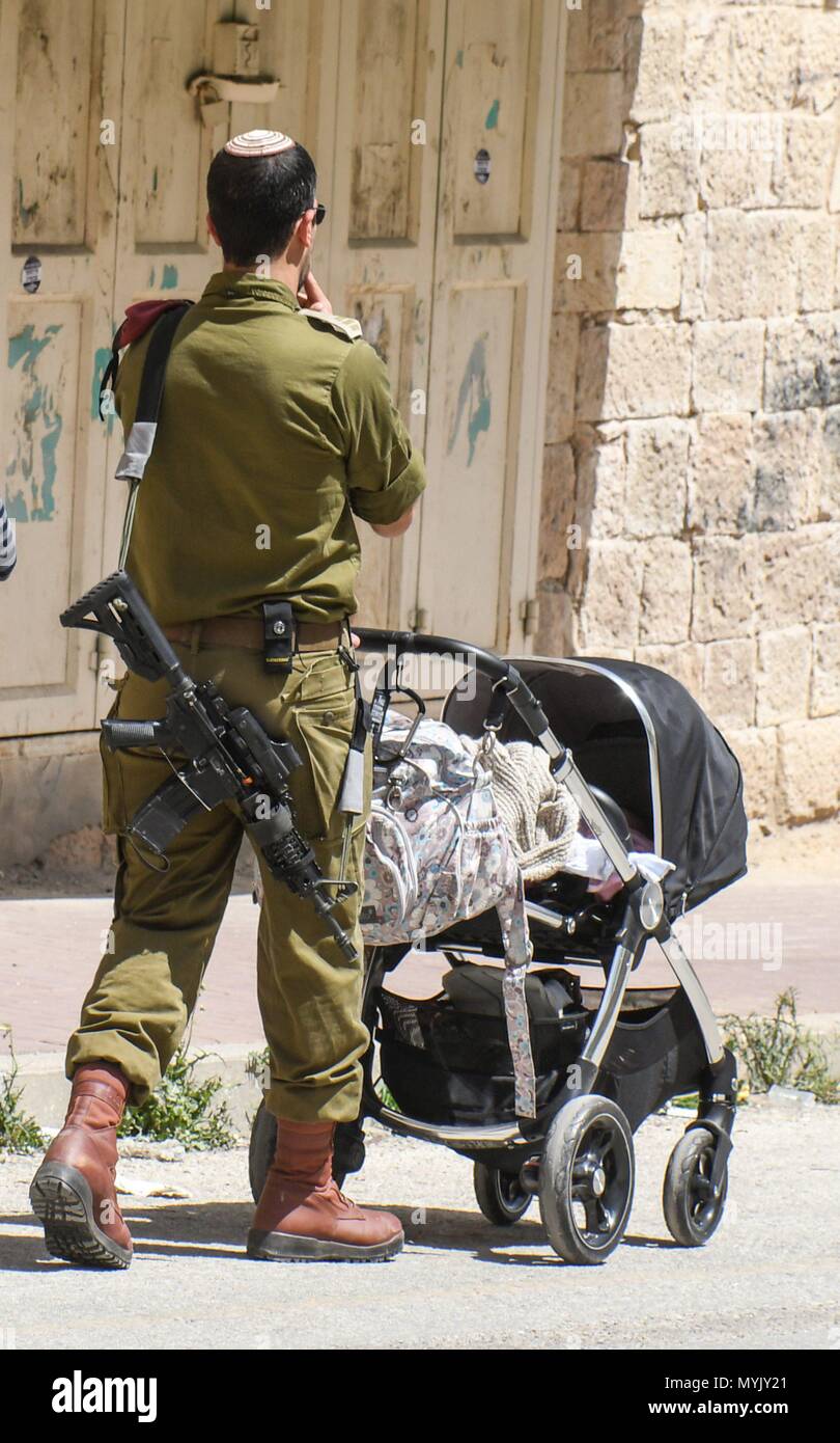 Israeli soldier with gun and buggy , Hebron, April 4, 2018 usage
