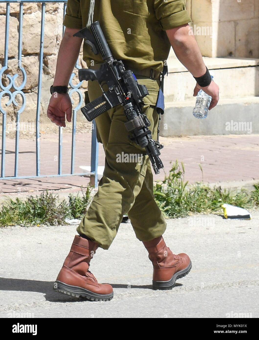 Israeli soldier with gun and buggy , Hebron, April 4, 2018 usage