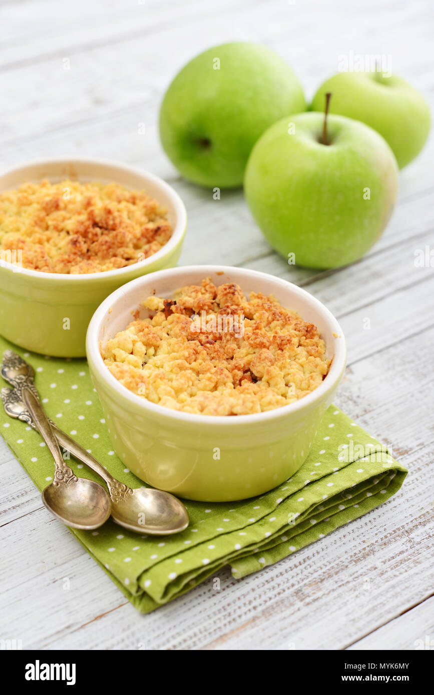 Apple crumble in small baking dish with fresh apples on wooden background Stock Photo Alamy