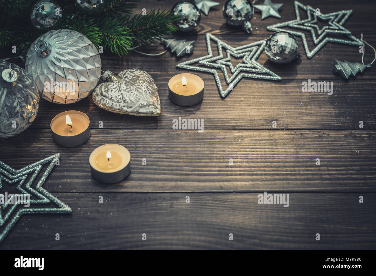 Christmas decorations with stars, fir tree twig  and candles on wooden background, closeup Stock Photo