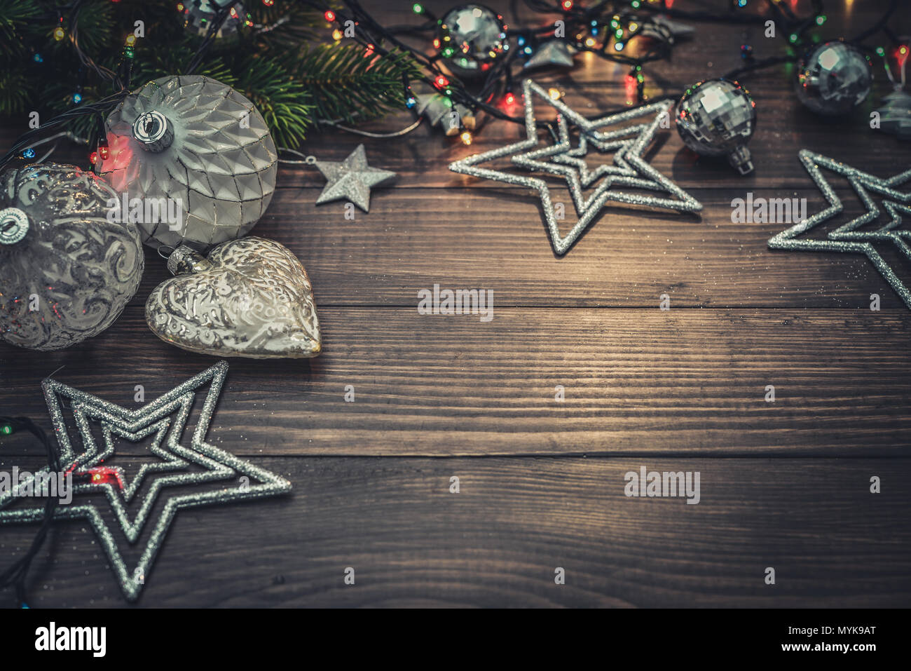 Christmas decorations with stars, fir tree twig  and christmas lights on wooden background, closeup Stock Photo