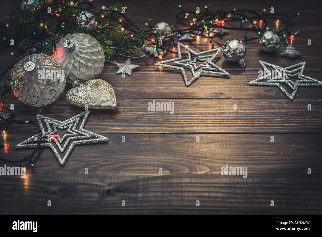 Christmas decorations with stars, fir tree twig  and christmas lights on wooden background Stock Photo