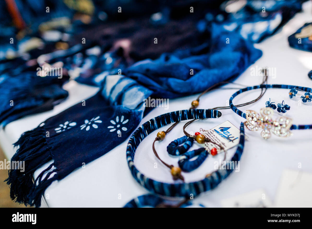 Indigodyed clothes and fashion accessories are seen placed on a table