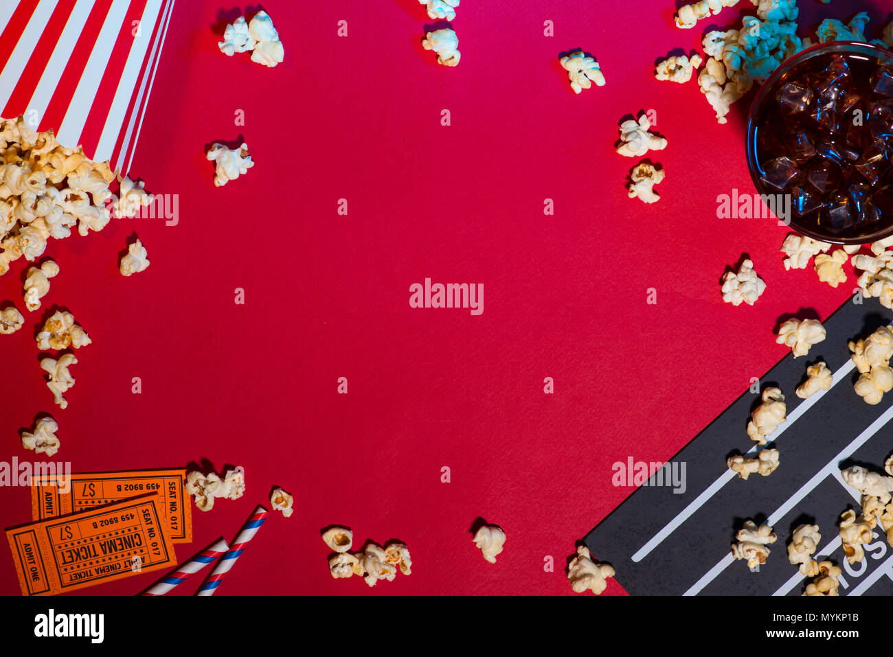 Movie tickets, clapperboard, pop corn on red background Stock Photo