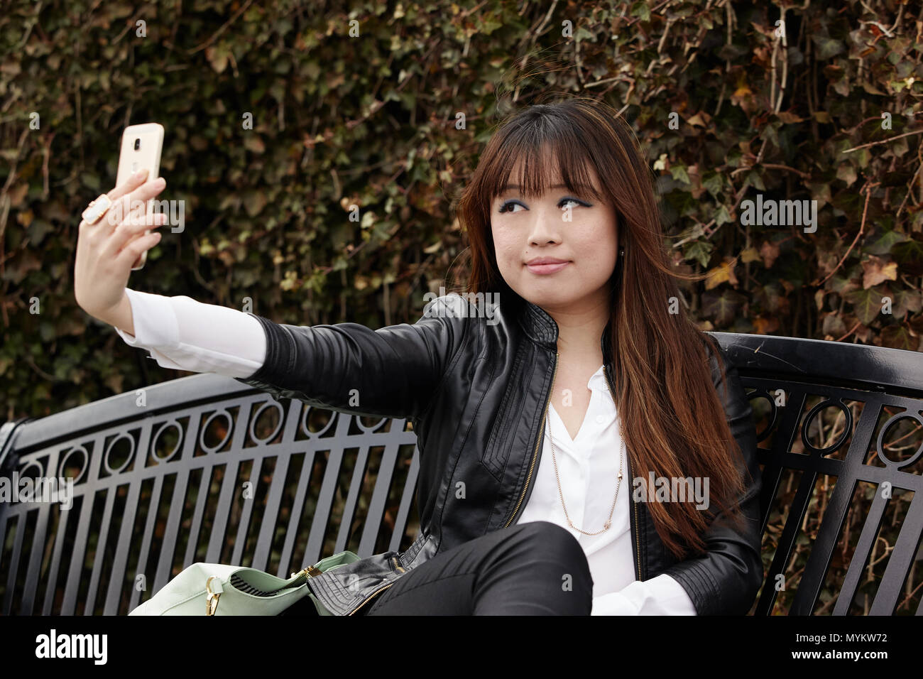 asian woman using cellphone outside Stock Photo