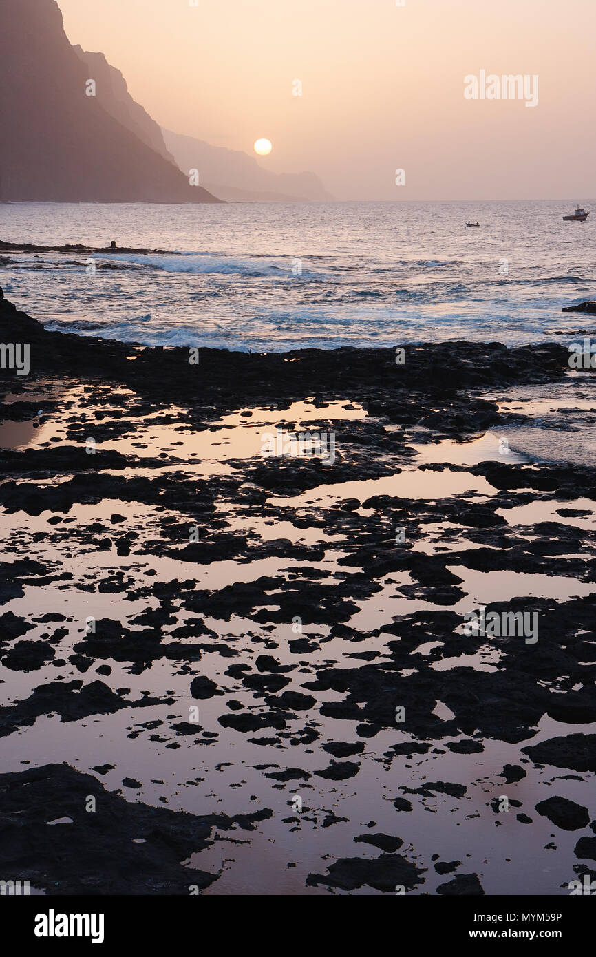 Cape Verde sunset at the rocky beach of Santo Antao Island. Mountains at the ocean Stock Photo