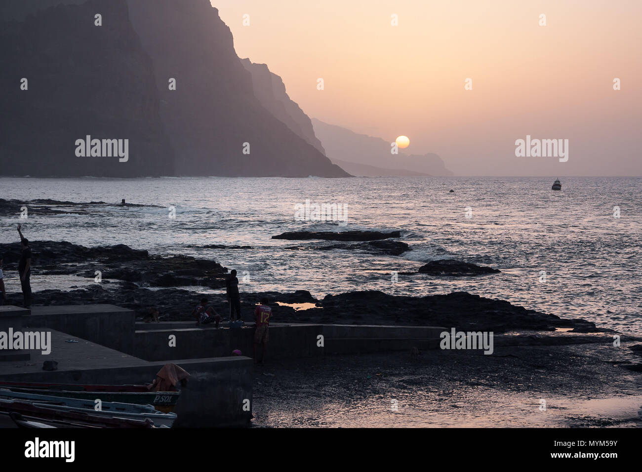 PONTA DO SOL, CAPE VERDE - DECEMBER 08, 2015: Beautiful sunset evening at the rocky shore of Santo Antao Island. People walking and watching the Sun,  Stock Photo