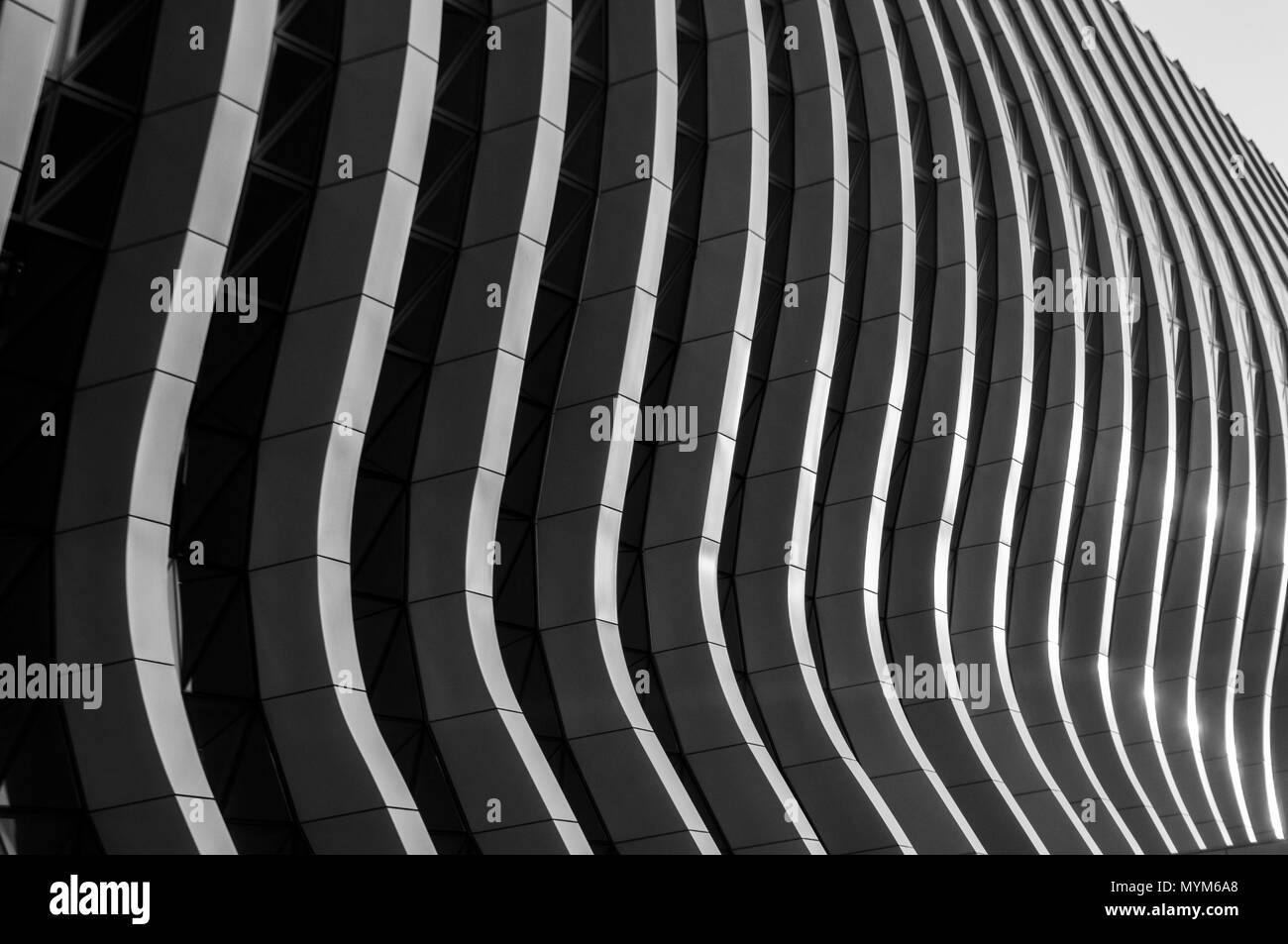 Contemporary geometric facade of a building with wavy lines in monochrome. Stock Photo
