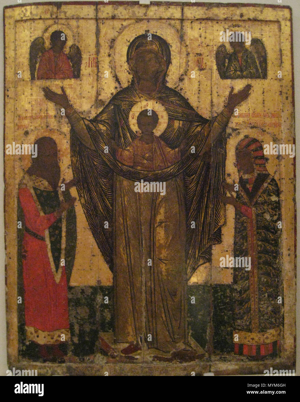 . Our lady of Mirozh with pskov prince S. Dovmont and his wife S.Maria. Pskov museum. Список с чудотворной иконы Мирожской божьей матери, хранящейся в Мирожском монастыре. Псковский музей. Богоматерь на этой святой иконе изображена во весь рост стоящею с воздетыми руками и с предстоящими Ей святыми князьями Довмонтом Псковским и его супругой Марией Дмитриевной, начертанными на иконе уже после ее явления; празднование в честь ее совершается 24 сентября. БОГОМАТЕРЬ ВЕЛИКАЯ ПАНАГИЯ (МИРОЖСКАЯ ОРАНТА). 1583 (?) год. Псков. Дерево; темпера. 144 x 112 x 3. Поступила в 1926 (?) году из церкви св. Сте Stock Photo