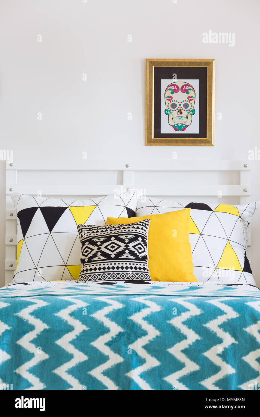 Scandinavian white bed with colorful pillows and mixed patterns Stock Photo