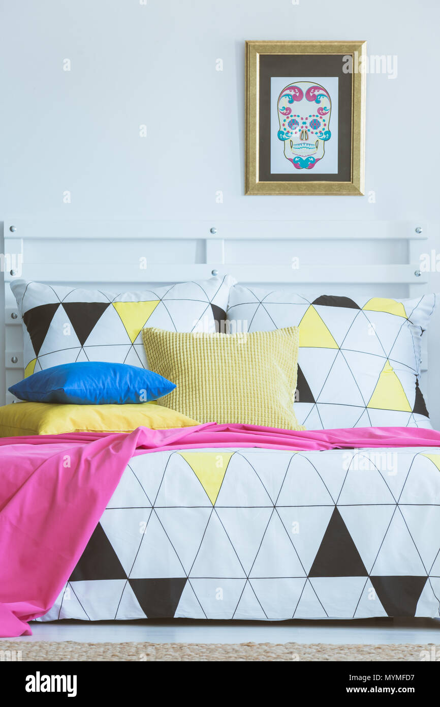 Scandinavian bedroom interior inspiration, colorful patterned bed in white room Stock Photo