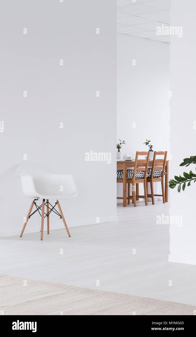 White clear spacious interior with wooden dining table Stock Photo