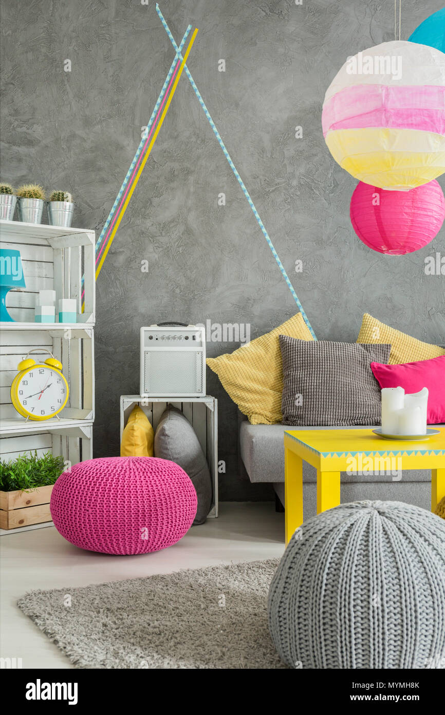 Image of a grey room with DIY wooden futniture, wool poufs and comfortable sofa Stock Photo