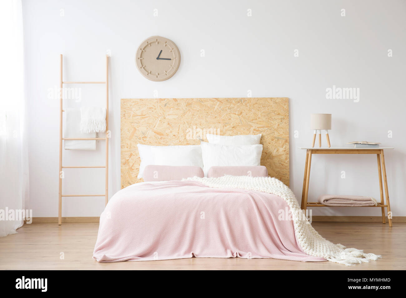 Large ladder standing next to a double bed in a modern interior of a bedroom Stock Photo