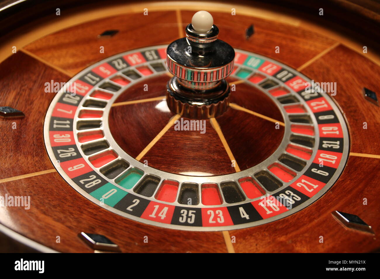 Calling all gamblers: roulette wheel, caps table, and poker chips. Stock Photo