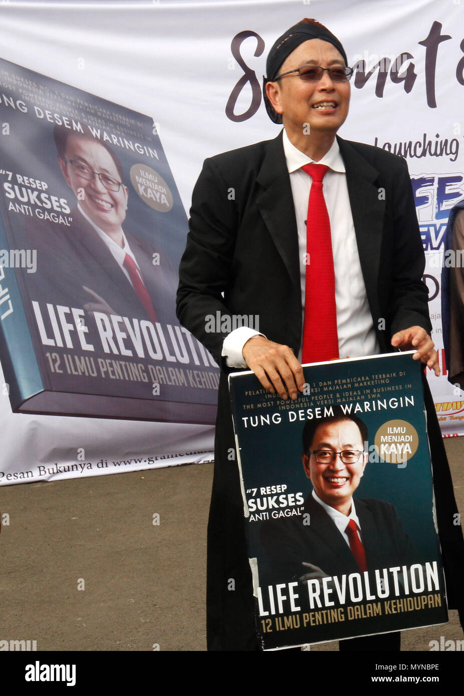 Jakarta, Indonesia. 07th June, 2018. Indonesian motivator, Tung Desem Waringin holding a book during raining money at pre launching book Live Revolutionin Jakarta, DKI Jakarta province, Indonesia. TDW is popular Indonesian motivator. Credit: Dadang Trimulyanto/Pacific Press/Alamy Live News Stock Photo