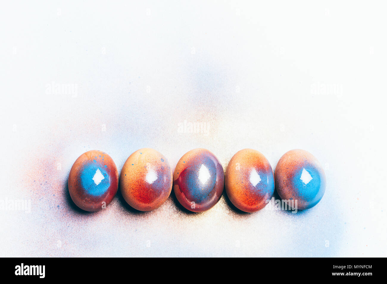 Five colorful shiny eggs on a white background. Easter egg. Handpainting. Stock Photo