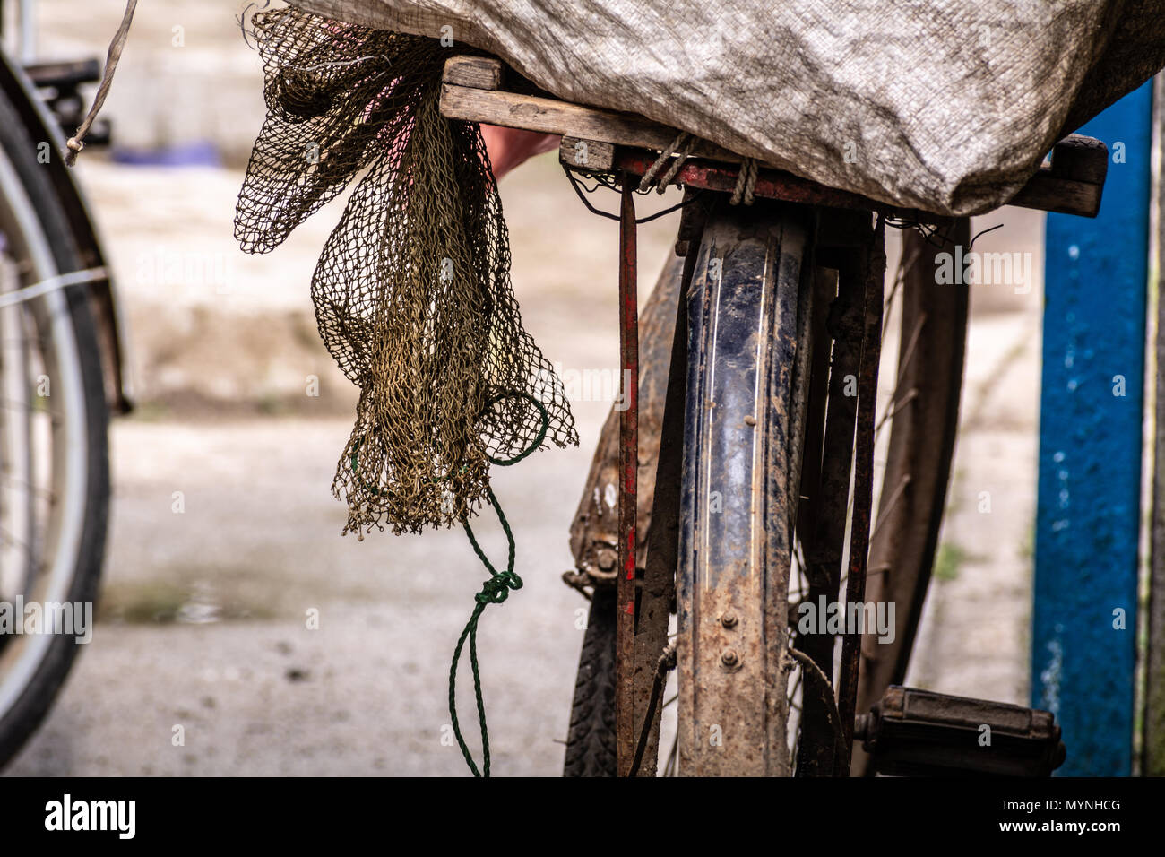 Fishing net covered with mud on the seat of an old bicycle Stock Photo -  Alamy