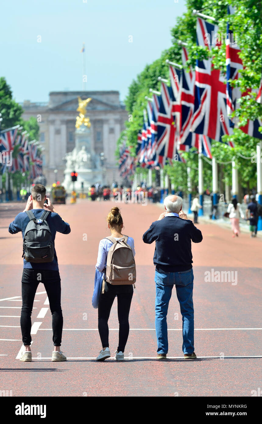 People photographing Buckingham Palace in the Mall while it is closed to traffic. London, England, UK. Stock Photo