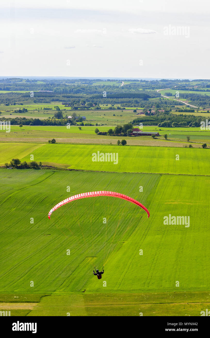 Paragliders flying over the fields in the countryside Stock Photo