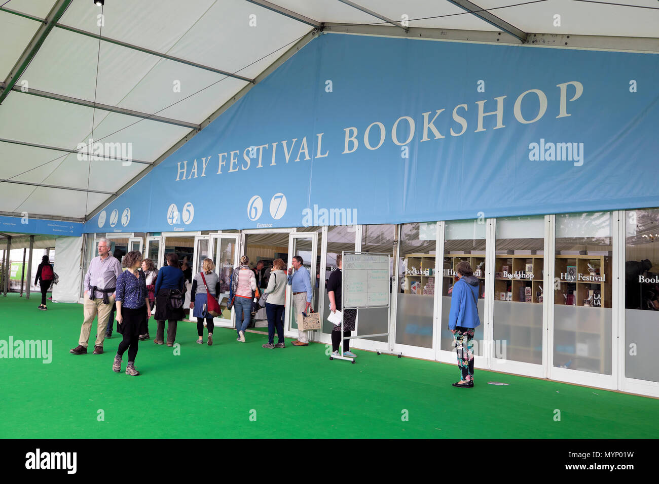 Visitors standing outside the Hay Festival marquee and sign