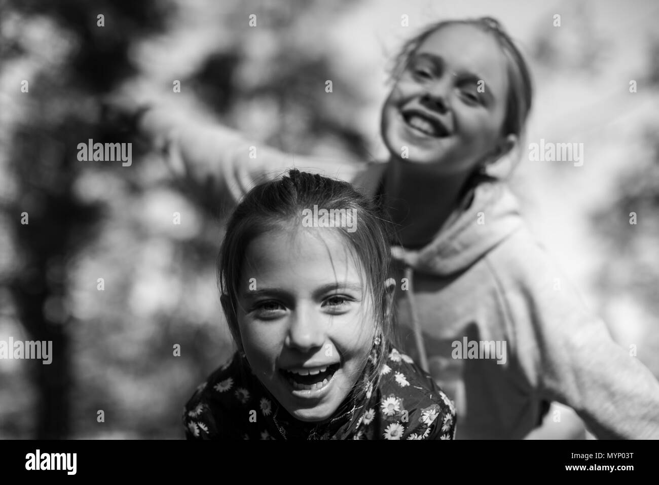 Two girls sisters or girlfriends having fun outdoors. Black and white. Stock Photo