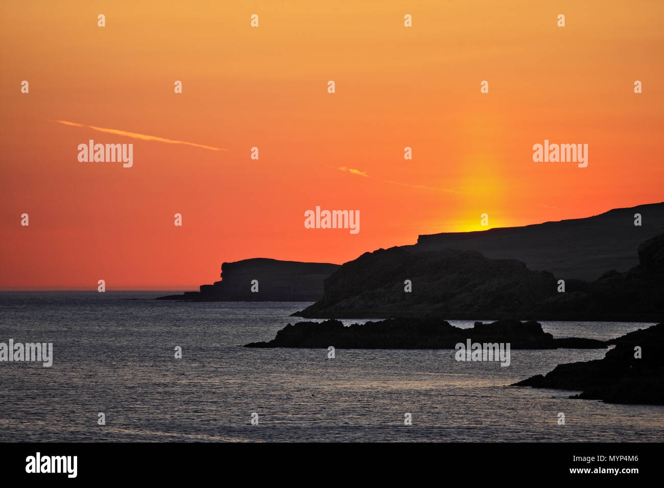 Sunset from Scourie Bay in Sutherland, north west Scotland with Handa Island, the furthest outline, silhouetted. Stock Photo