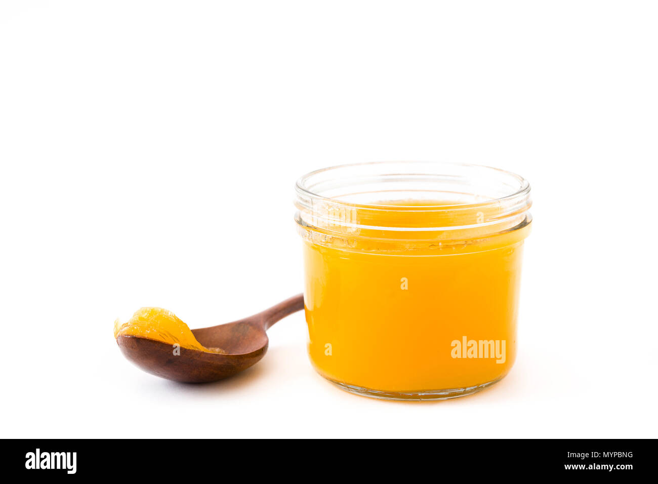 Ghee or clarified butter in jar and wooden spoon isolated on white