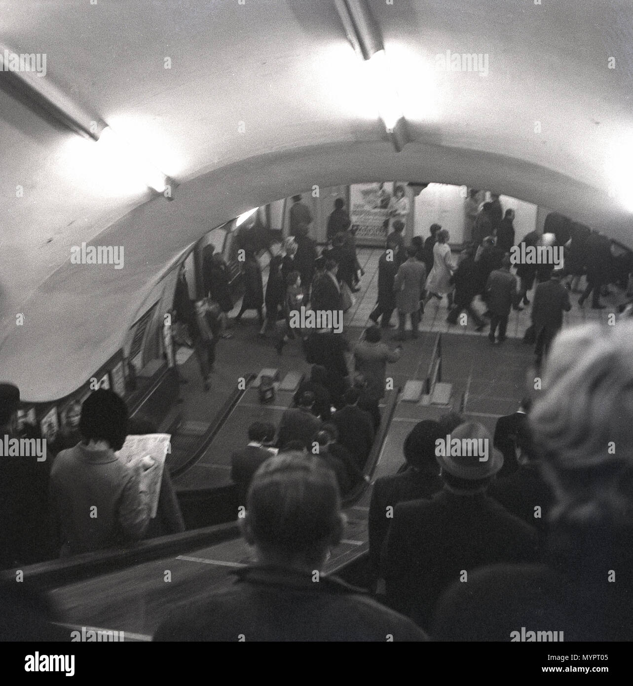 1960s, historical, people going down the wooden escalators on the London underground, the metro or mass transit system for the city London, to get to the platforms to board the trains. Stock Photo