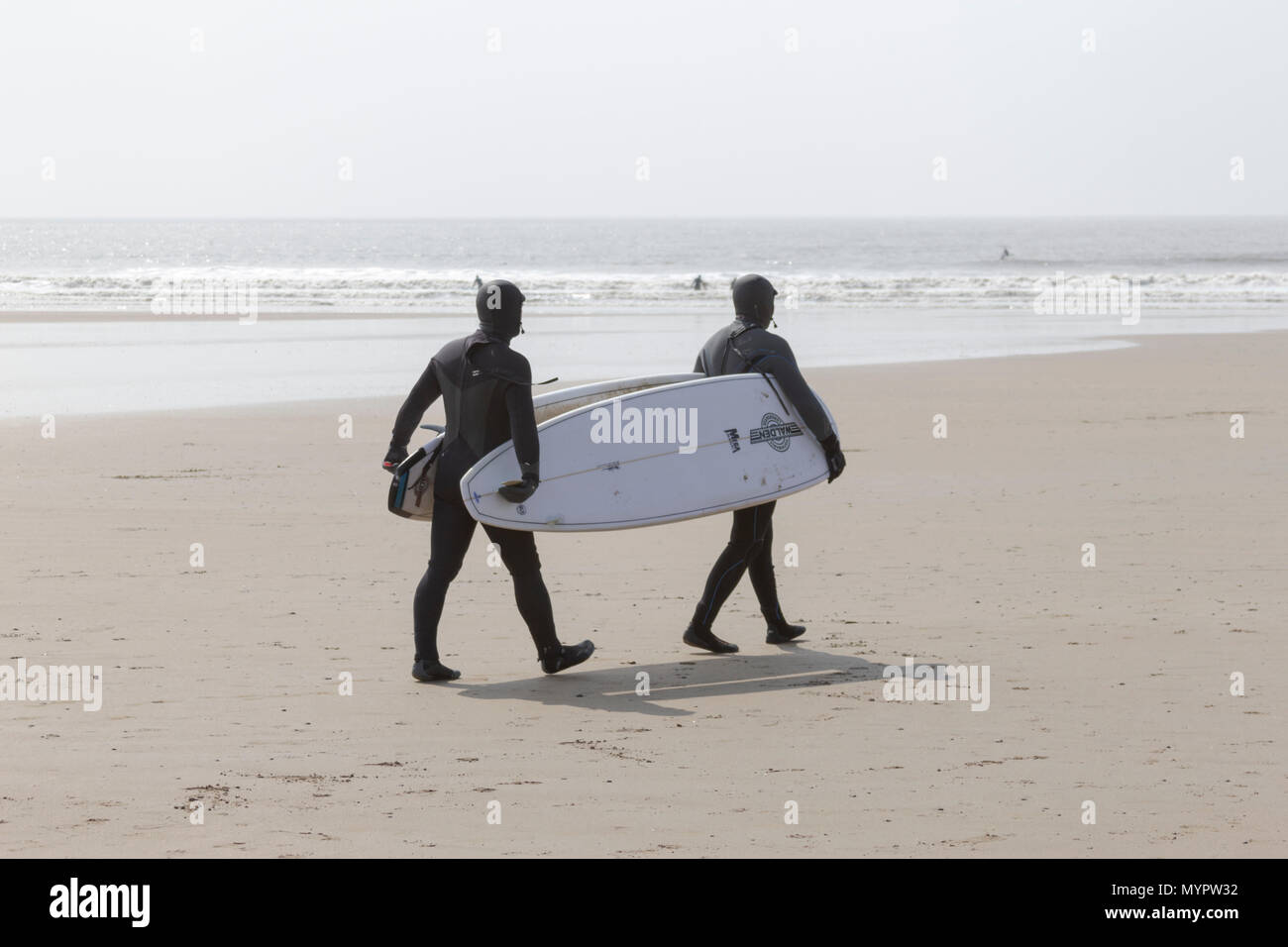 Surfers on the Beach, Porthcawl, Mid Glamorgan, Wales, UK. 14th April 2018. UK. UK Weather. Surfers on the beach preparing to surf on a sunny day. Stock Photo