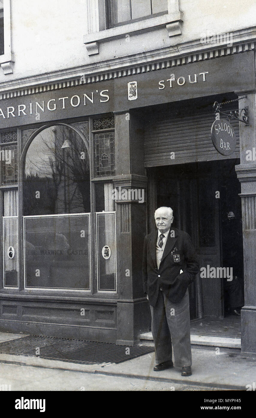 1934, elderly gentleman standing at the entrance outside The Warwick Castle Pub, Little Venice, London, England, UK. At this time it was a Charrington's public house, with Anchor stout a popular brand. Stock Photo