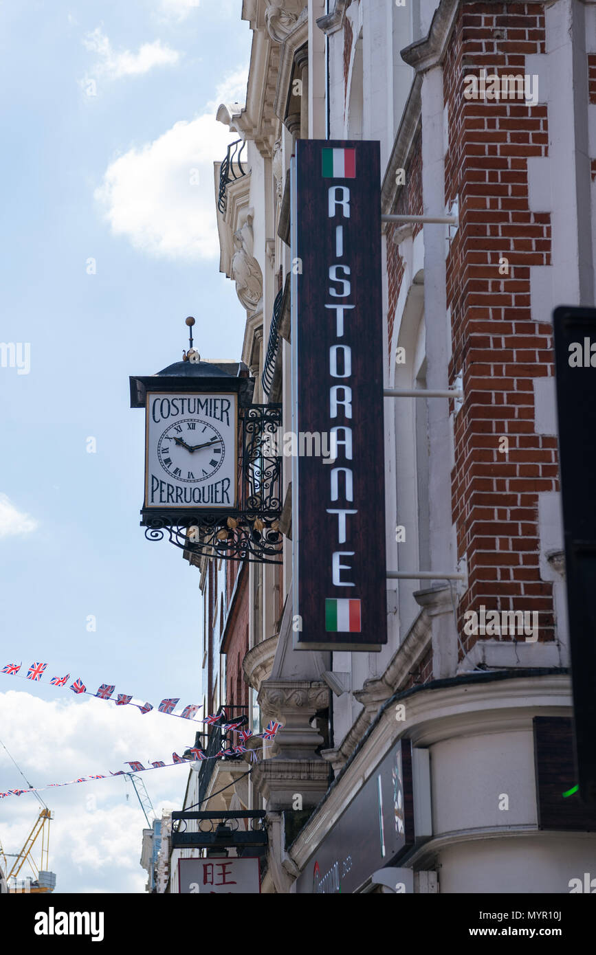 Italian restaurant wall sign and an ornate clock on a building in Soho,  London, England, UK Stock Photo - Alamy