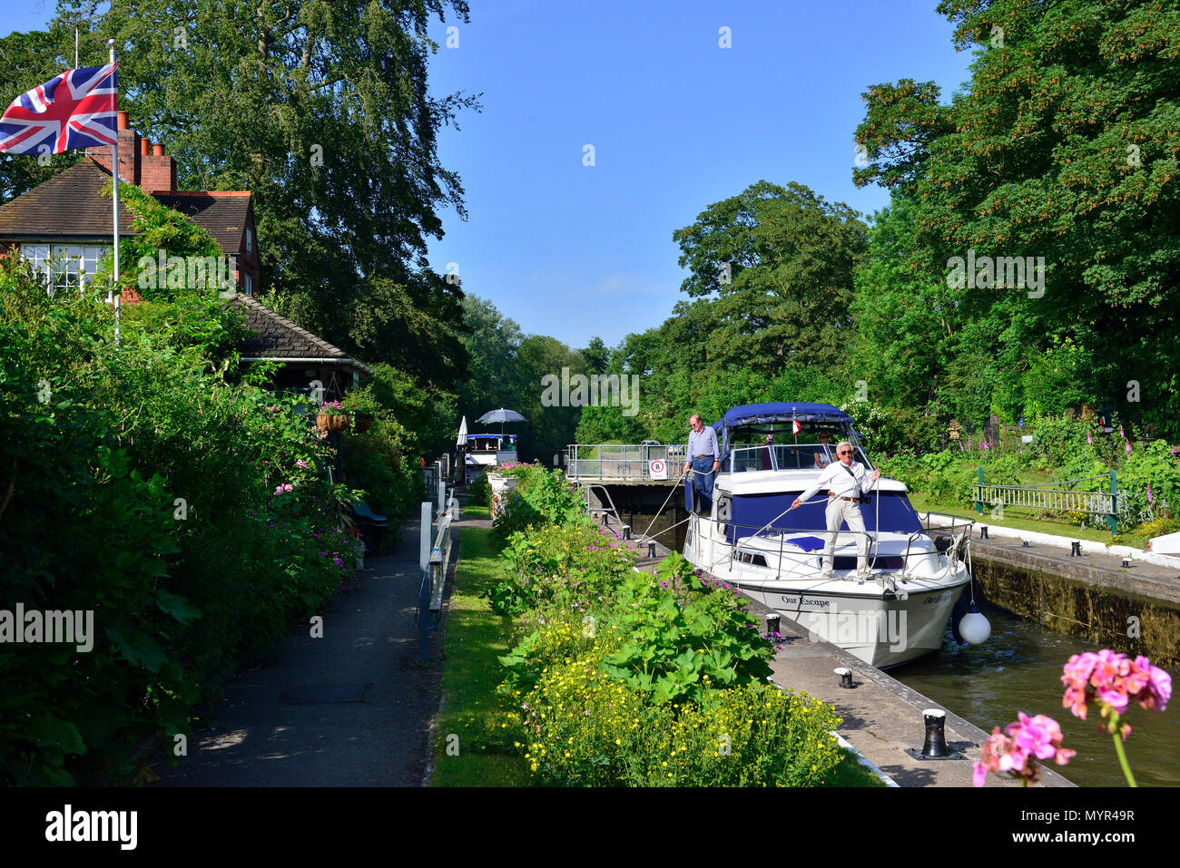 Private pleasure boat entering the Sonning Lock on the River Thames near the village of Sonning, Berkshire,on a beauiful sunny summers afternoon Stock Photo