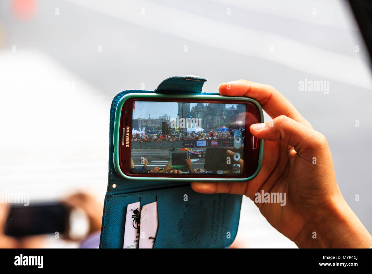 Mexico City, Mexico - June 27, 2015: Spectator taking video to a F1 Red Bull Racing RB7 car, at the Infiniti Red Bull Racing F1 Showrun. Stock Photo