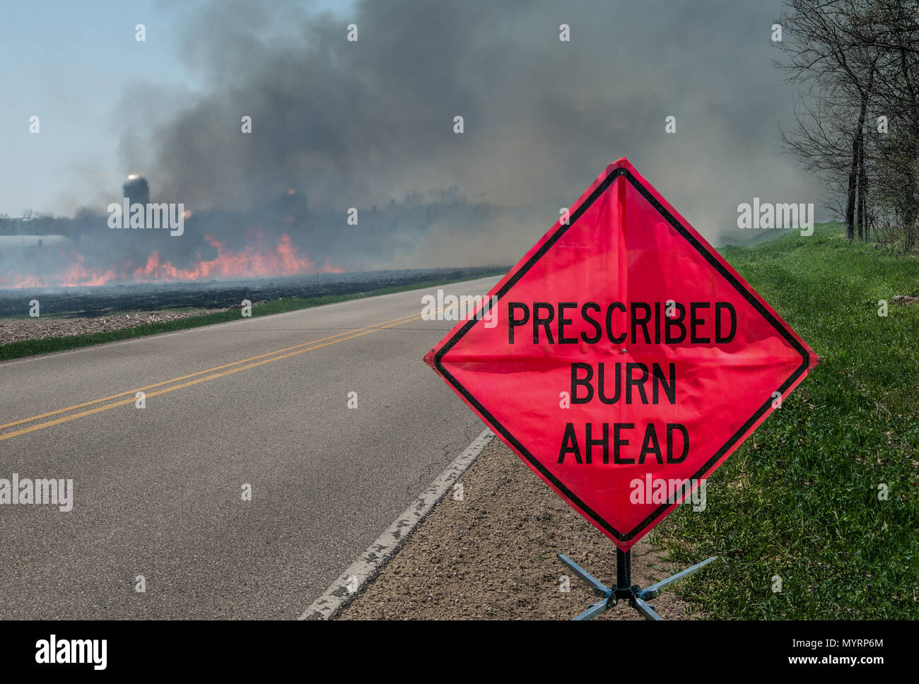 Prescribed Agricultural Burn Area and Sign:  A sign warns motorists of a controlled burn area ahead on a farm in southern Wisconsin. Stock Photo