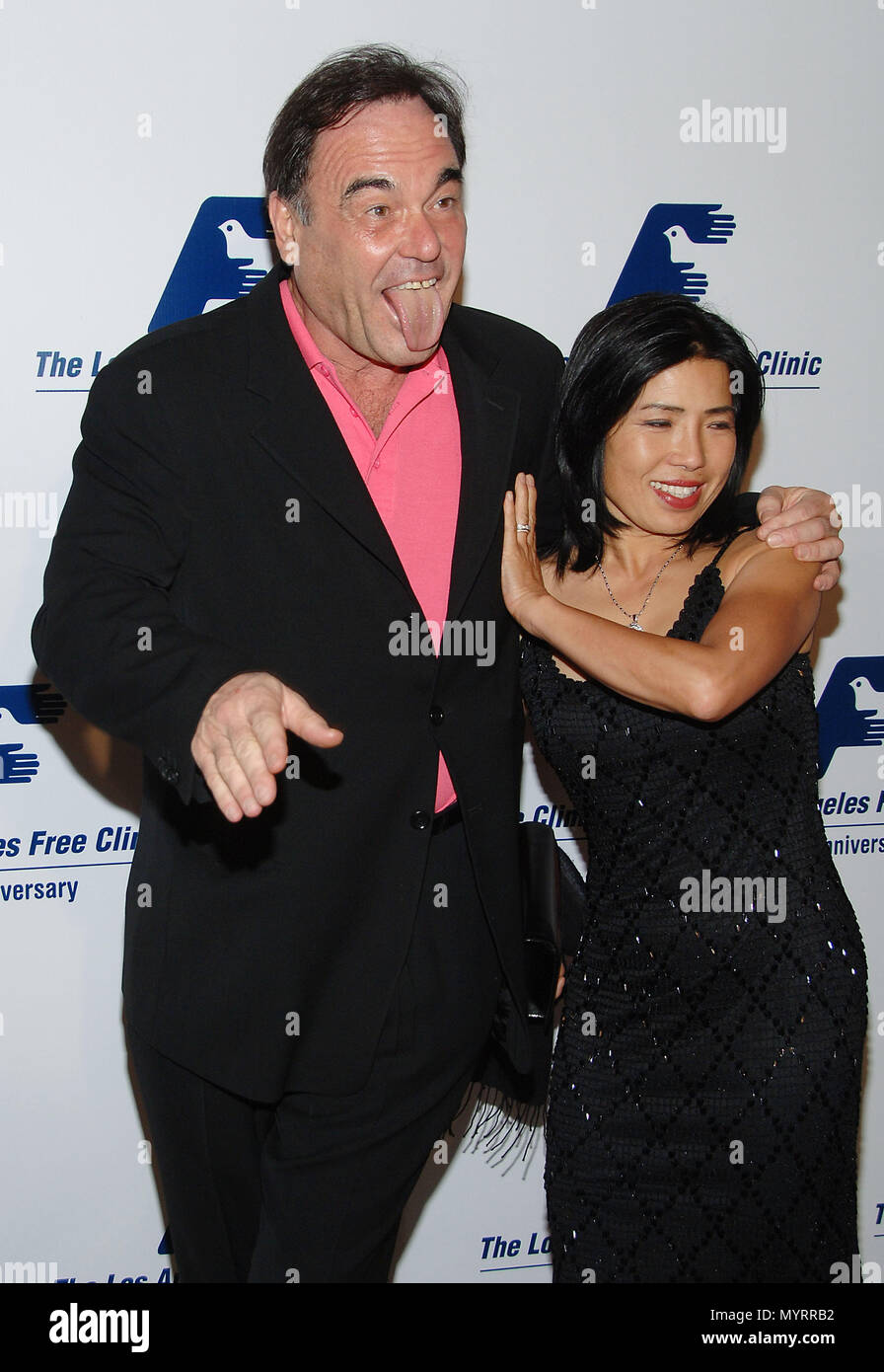 Oliver Stone and wife arriving at Los Angeles Free Clinic Dinner Gala at  the Beverly Hilton in Los Angeles. 3/4 tongue out 20 StoneOliver wife047  Event in Hollywood Life - California, Red