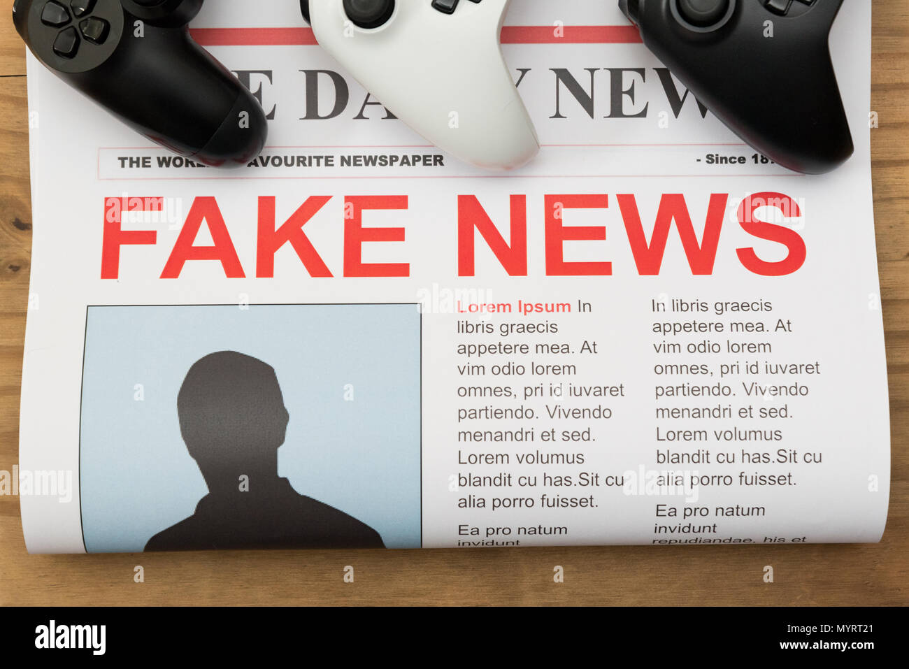 Newspaper with video game controllers with the headline fake news Stock