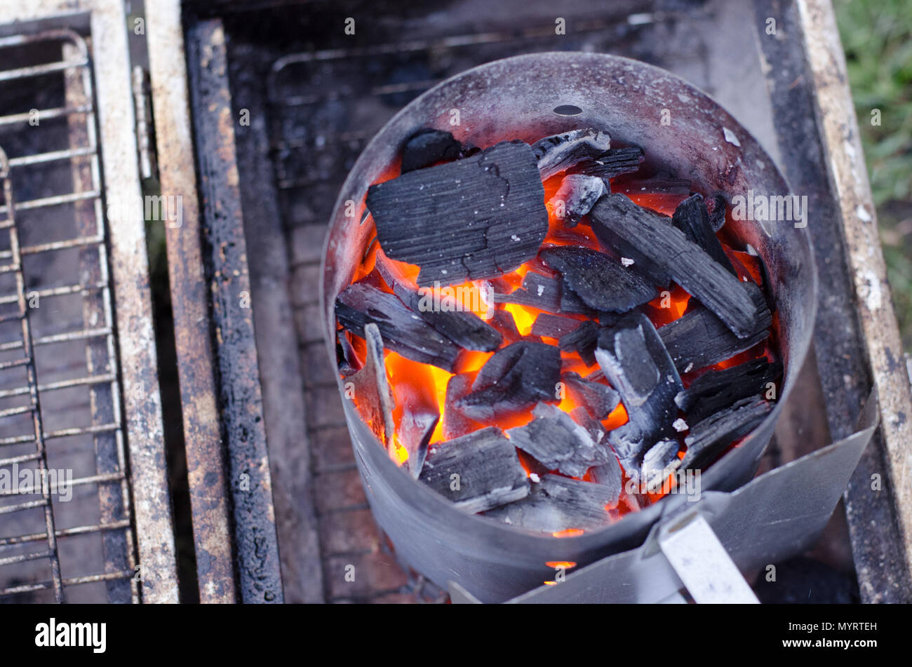 A chimney starter in use to get the charcoal ready for the grill in a