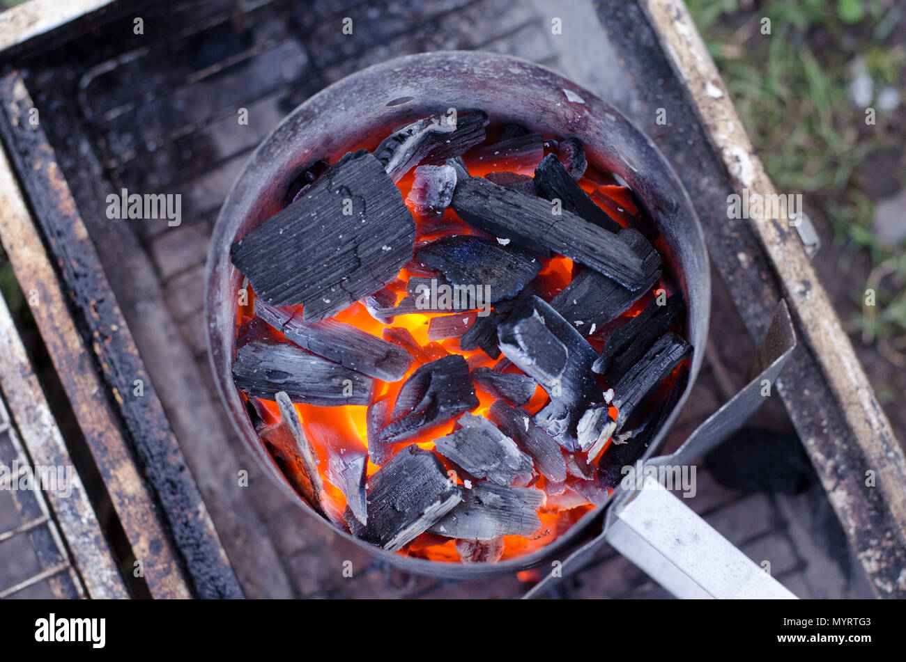 A chimney starter in use to get the charcoal ready for the grill in a
