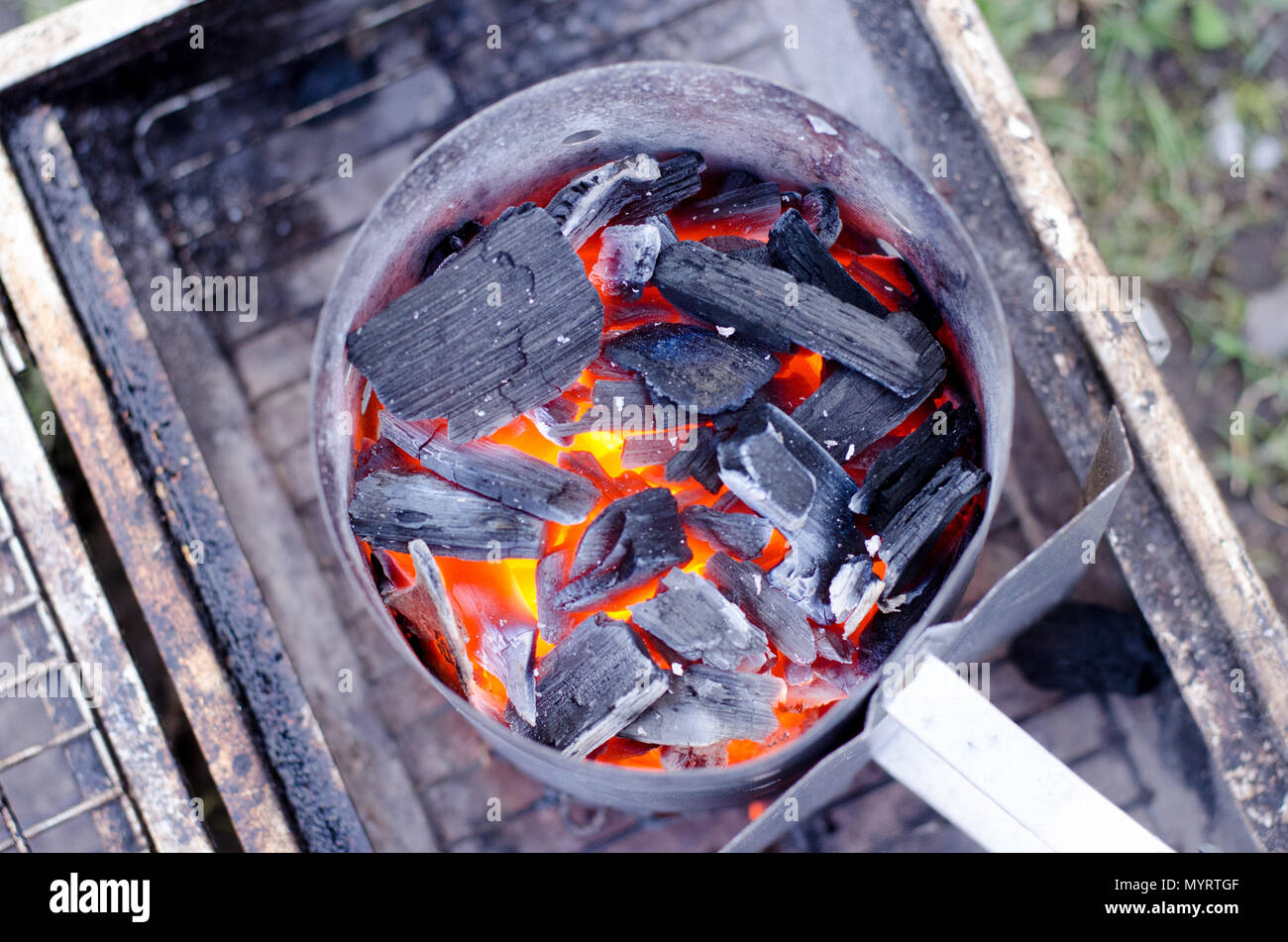 A chimney starter in use to get the charcoal ready for the grill in a