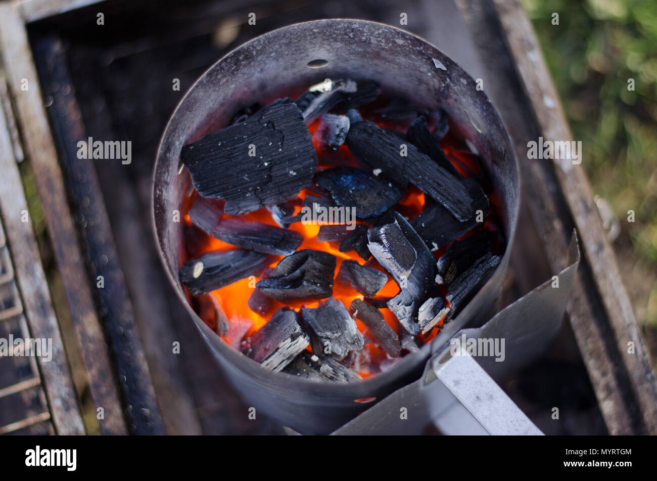A chimney starter in use to get the charcoal ready for the grill in a